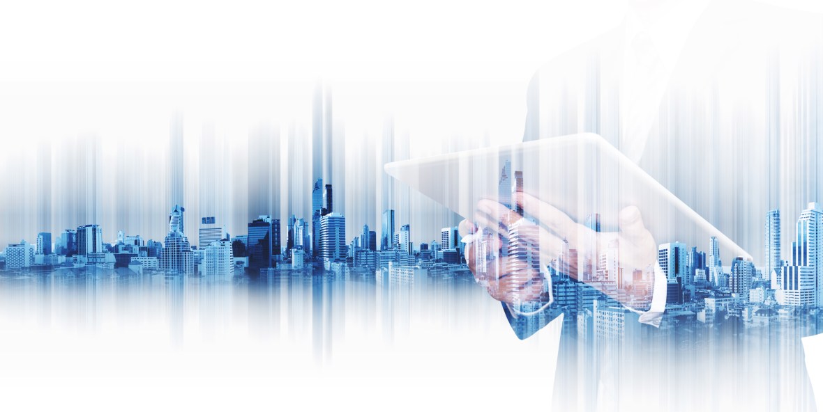 Businessman working on digital tablet, with double exposure city background